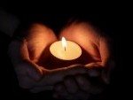 -holding-burning-candle-in-the-dark